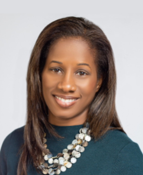 Staff member smiling at the camera in front of a grey background.
