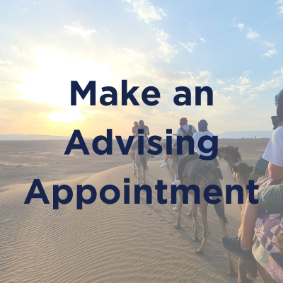 Group of students riding camels through a desert at sunset, with text overlay that reads 'Make an Advising Appointment'