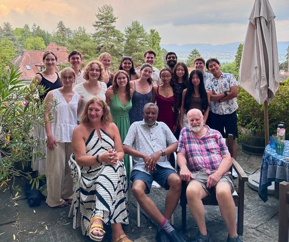 Students and faculty gathered outdoors for a group photo during a UConn Global study abroad program, with greenery and hills in the background.